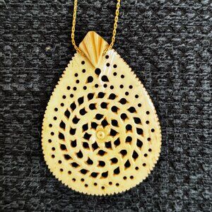 Delicate  carved bone pendant with floral design and gold plated 17-inch chain